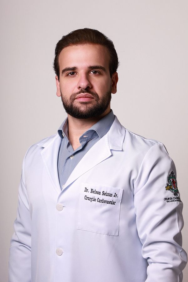 Dr. Nelson Seixas Jr. de jaleco branco, com nome e especialidade bordados