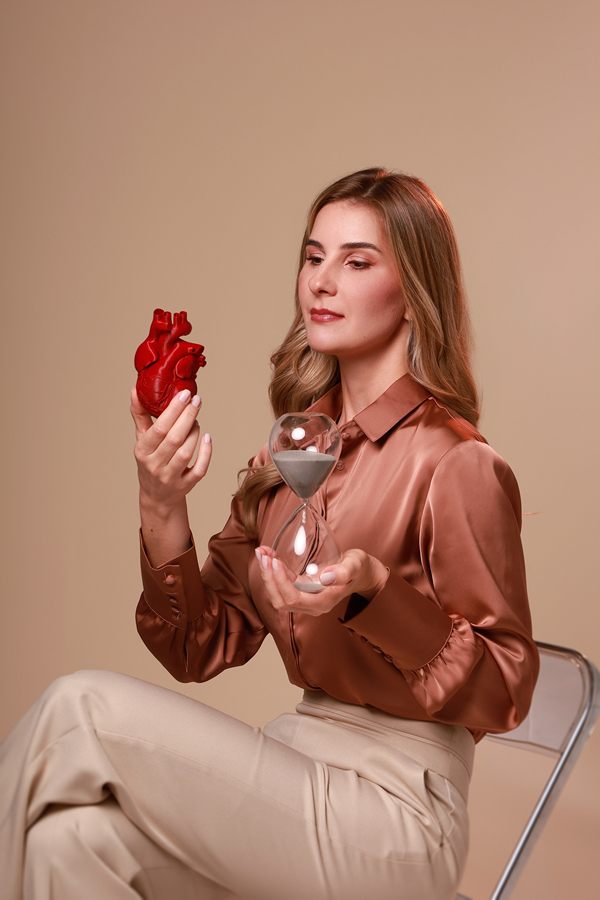 Dra. Mariana Borduchi segurando um modelo do coração e uma ampulheta