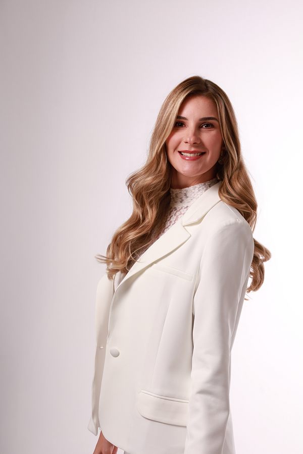 Dra. Mariana Borduchi sorrindo, de blazer branco